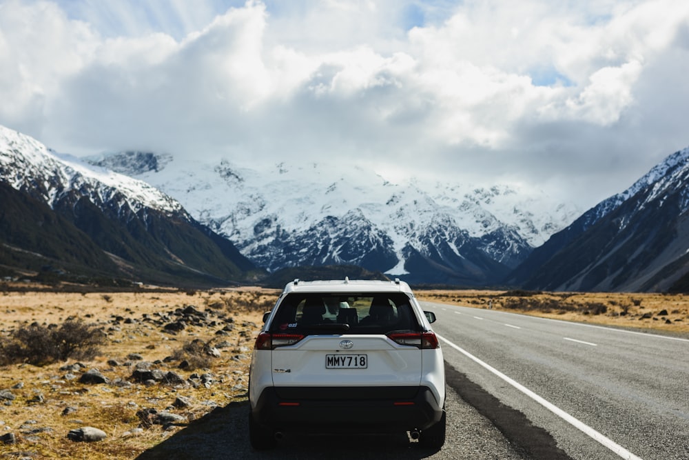 white suv on road near snow covered mountain during daytime