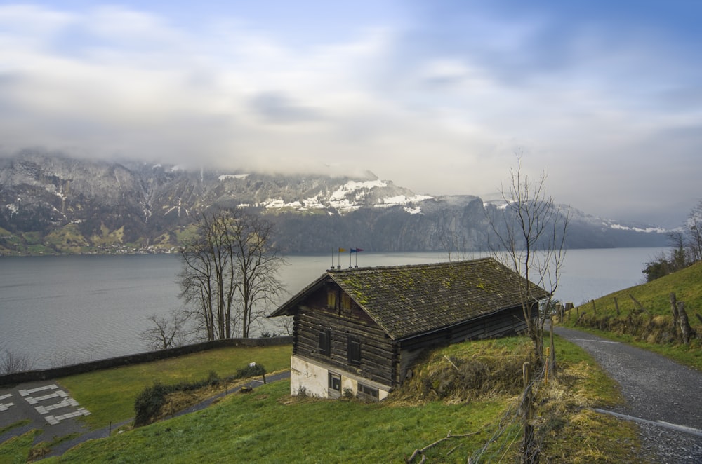 casa di legno marrone vicino allo specchio d'acqua durante il giorno