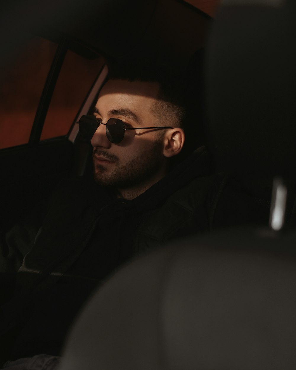 man in black sunglasses sitting inside car