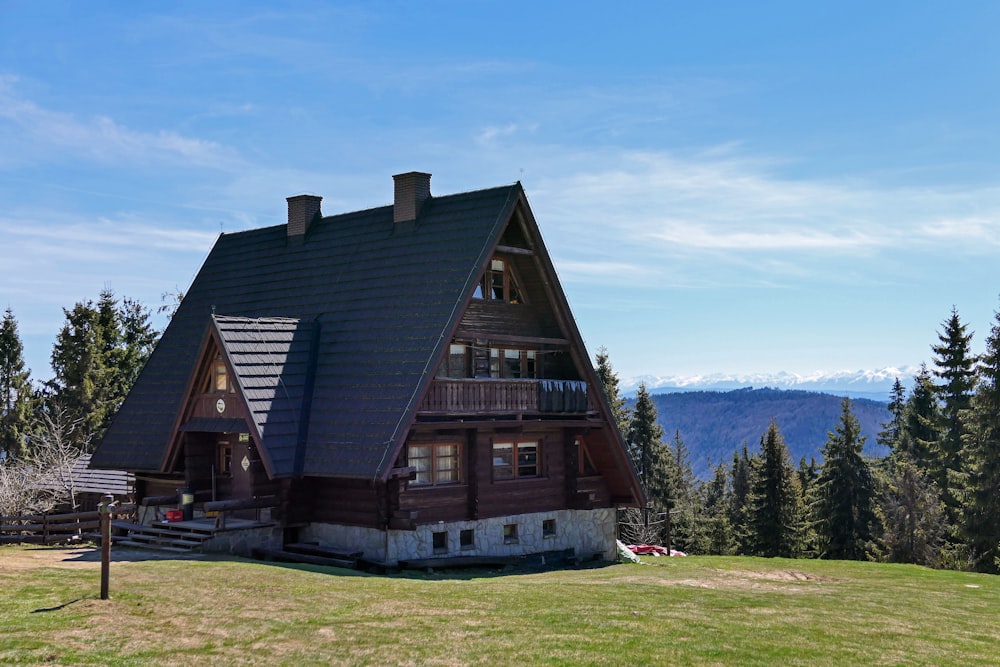 Casa de madera marrón y gris en campo de hierba verde durante el día