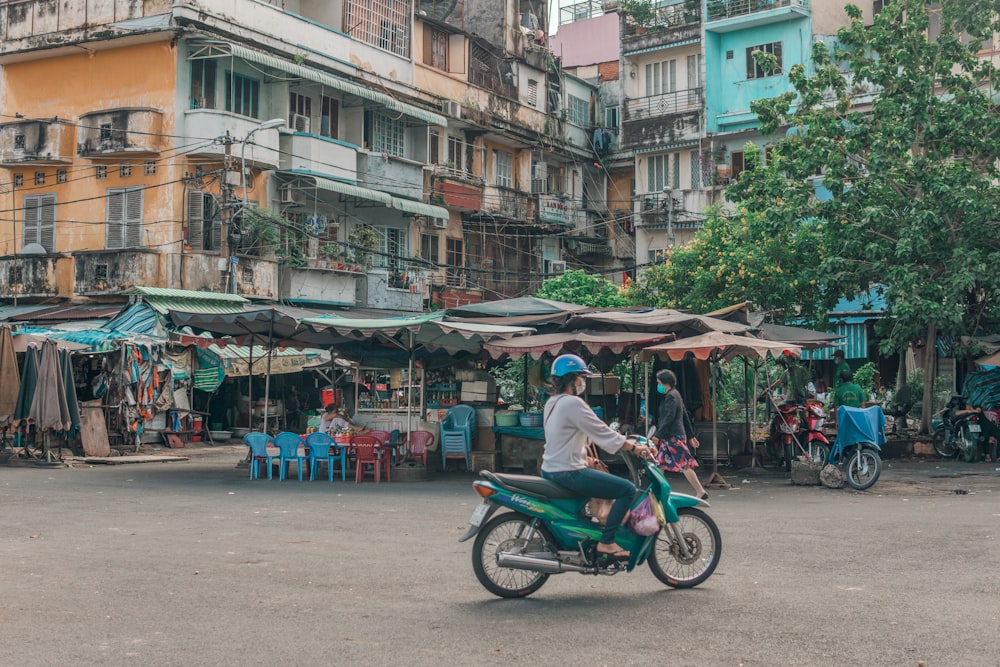 man in blue shirt riding on motorcycle during daytime