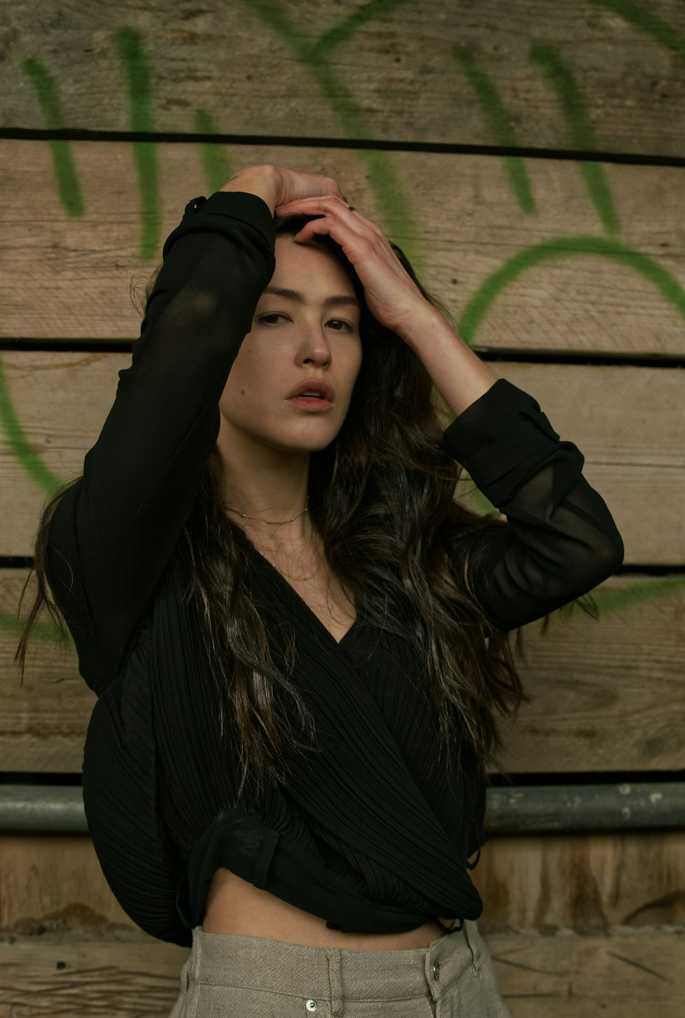 woman in black long sleeve shirt covering her face with her hands