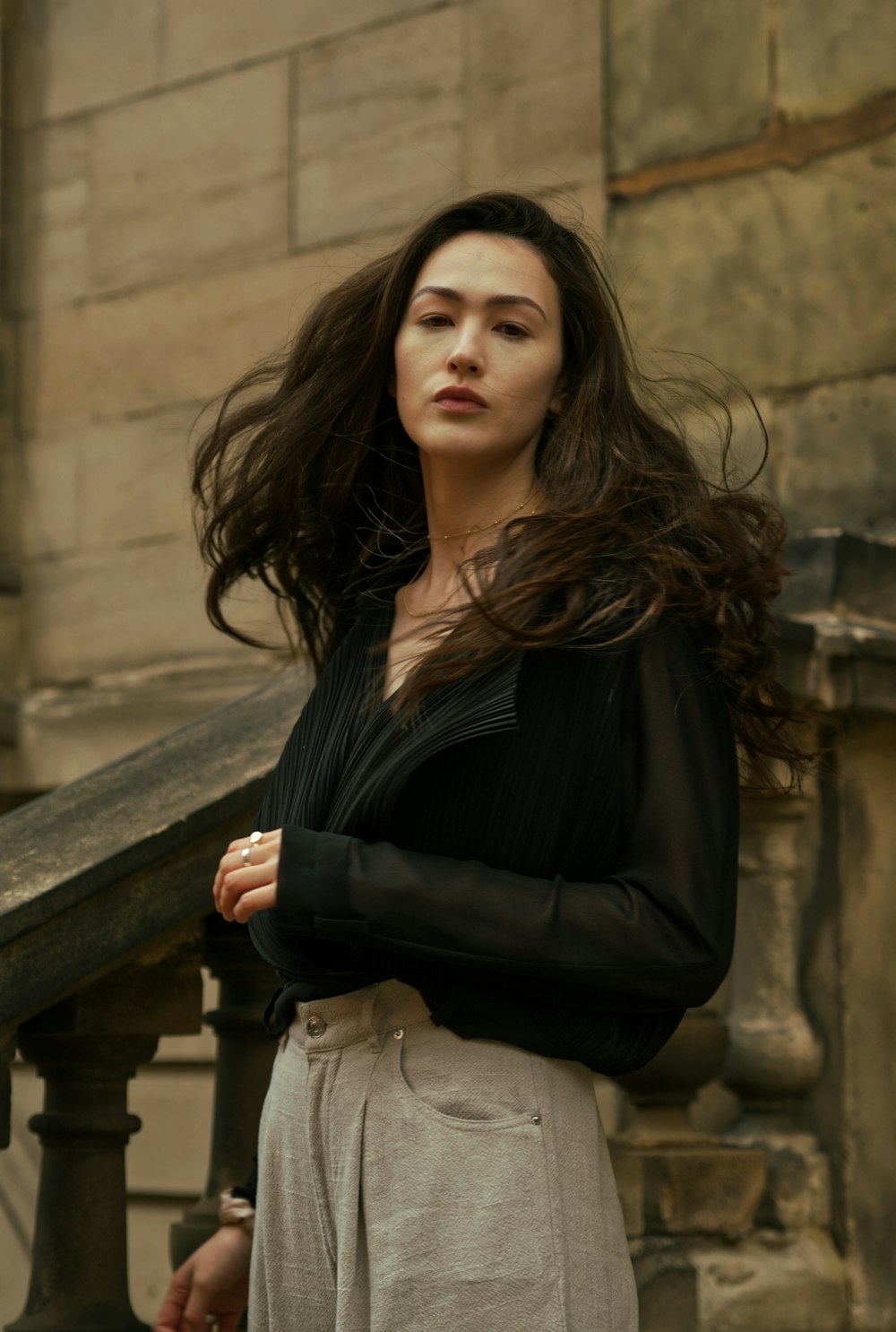 Femme en chemise noire à manches longues assise sur un banc en bois marron