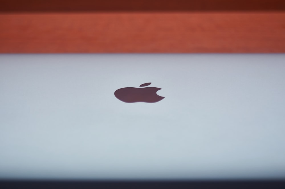 silver macbook on brown wooden table