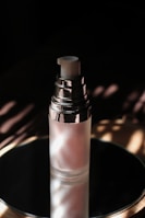 Artistic shot of the wittkas lash serum bottle surrounded by golden light reflections