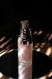 Elegant glass bottle of shimmering highlighter catching the light.