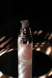 Elegant glass bottle of shimmering highlighter catching the light.