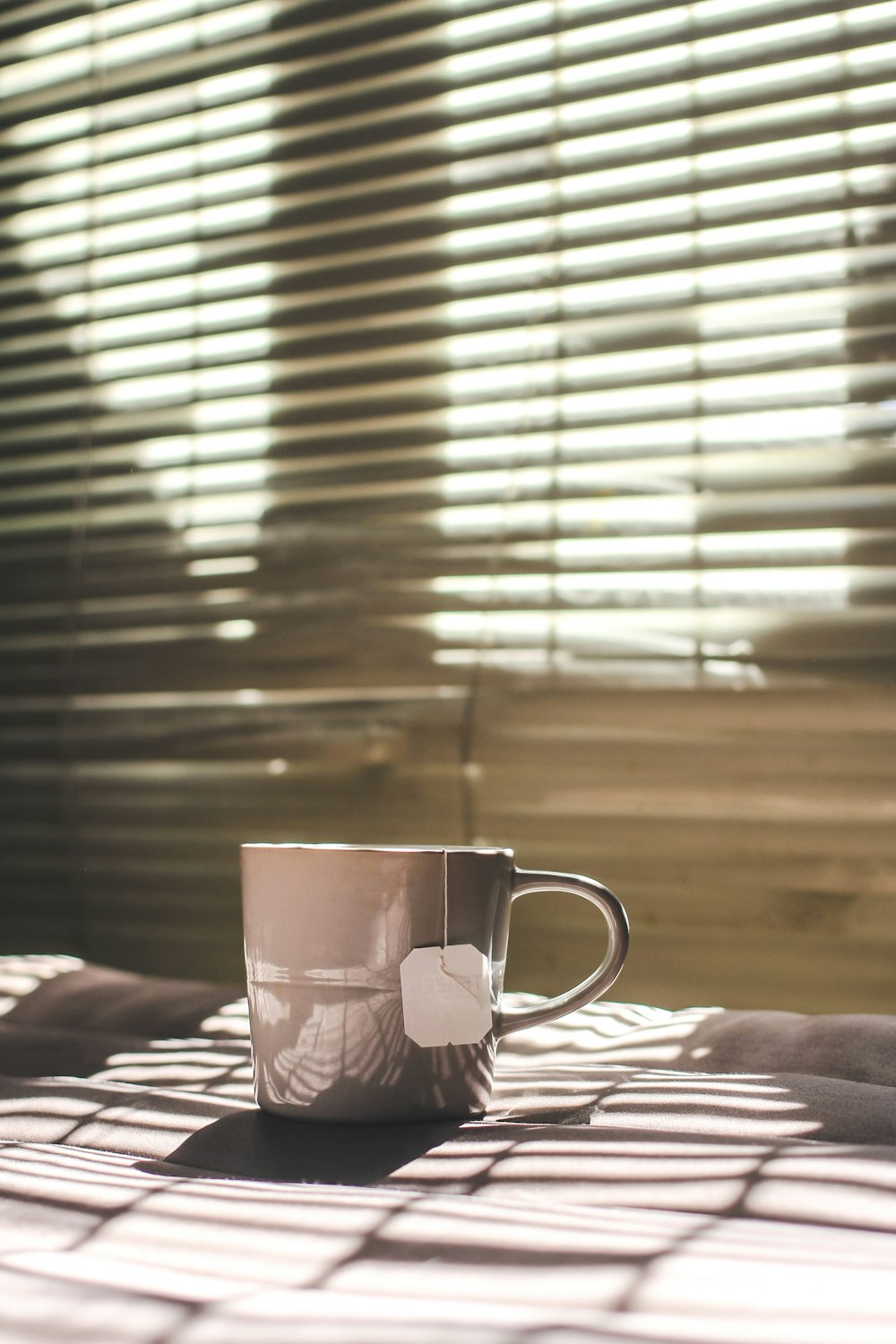 white and red ceramic mug on brown wooden table