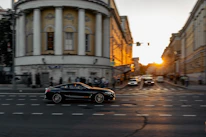 A sleek taxi car driving through busy Mexico City streets at sunset.