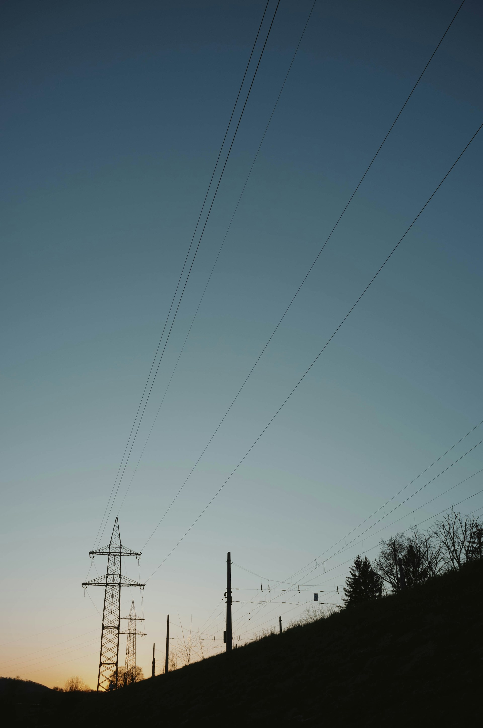 the silhouette of power lines against a blue sky