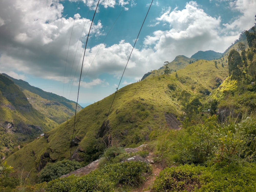 green and brown mountains under white clouds and blue sky during daytime