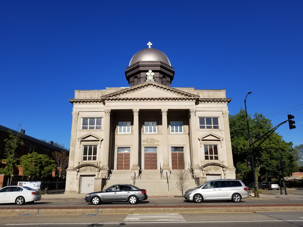 cars parked in front of beige concrete building during daytime