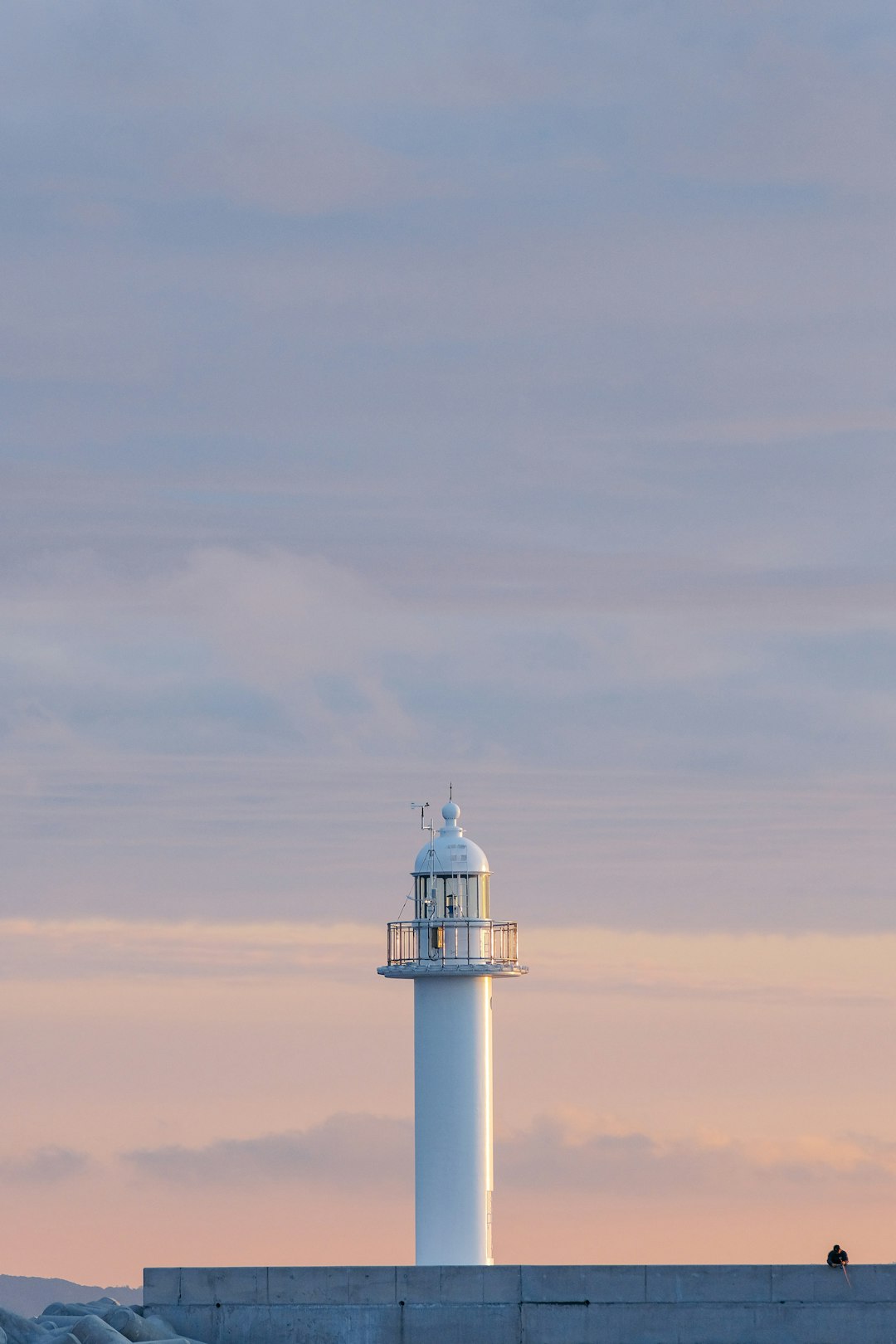 white and black lighthouse under white clouds during daytime