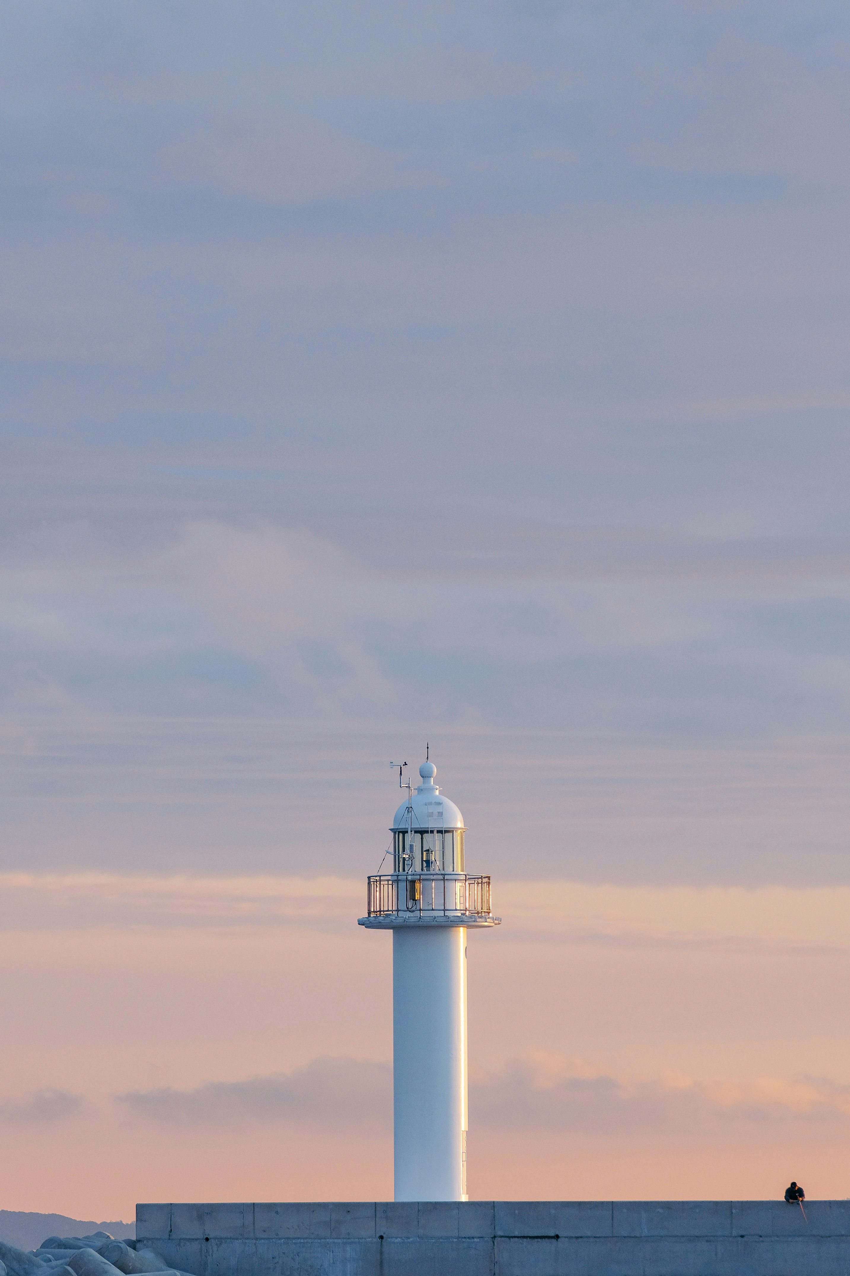 white and black lighthouse under white clouds during daytime