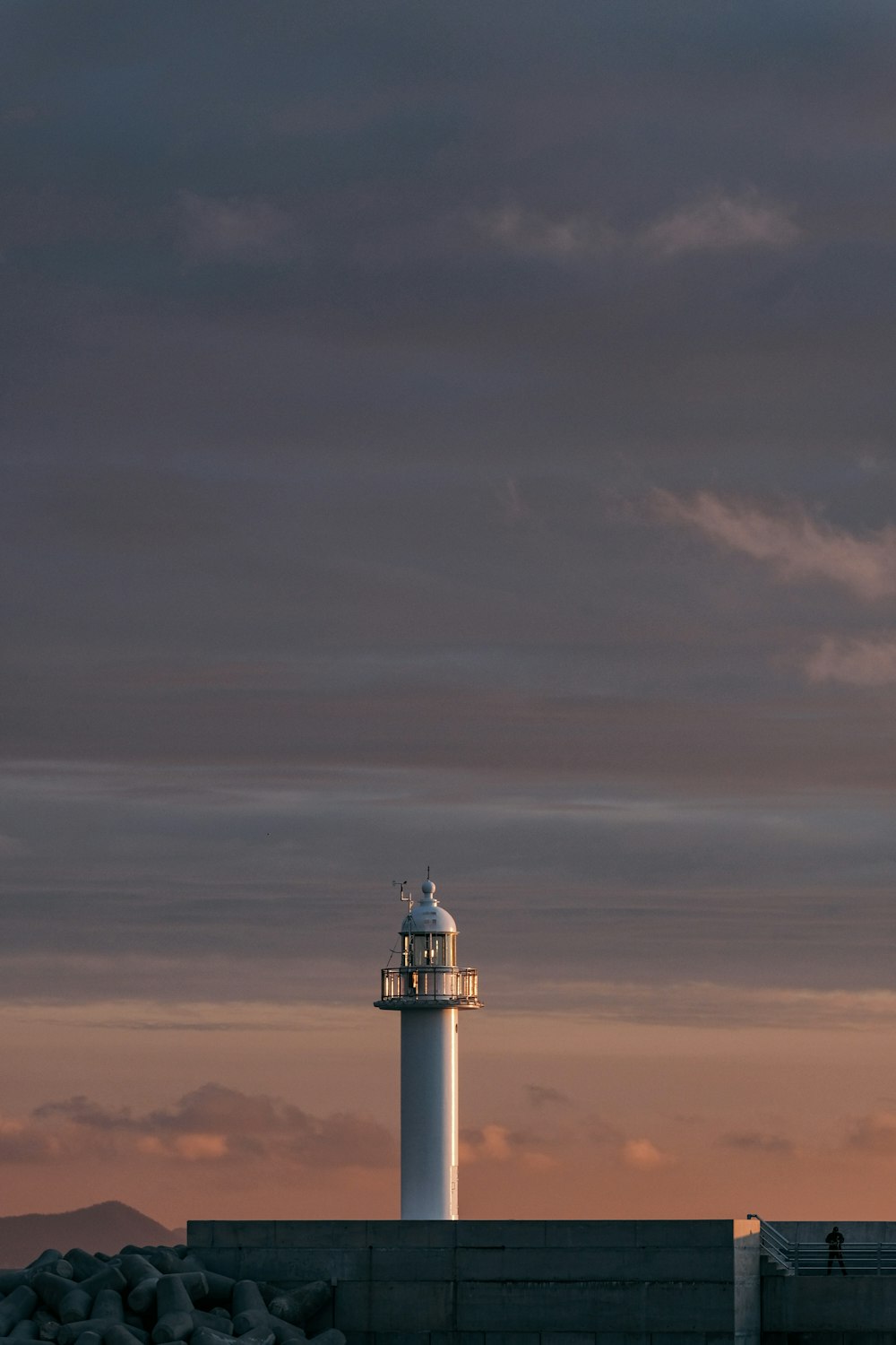 white lighthouse under gray clouds