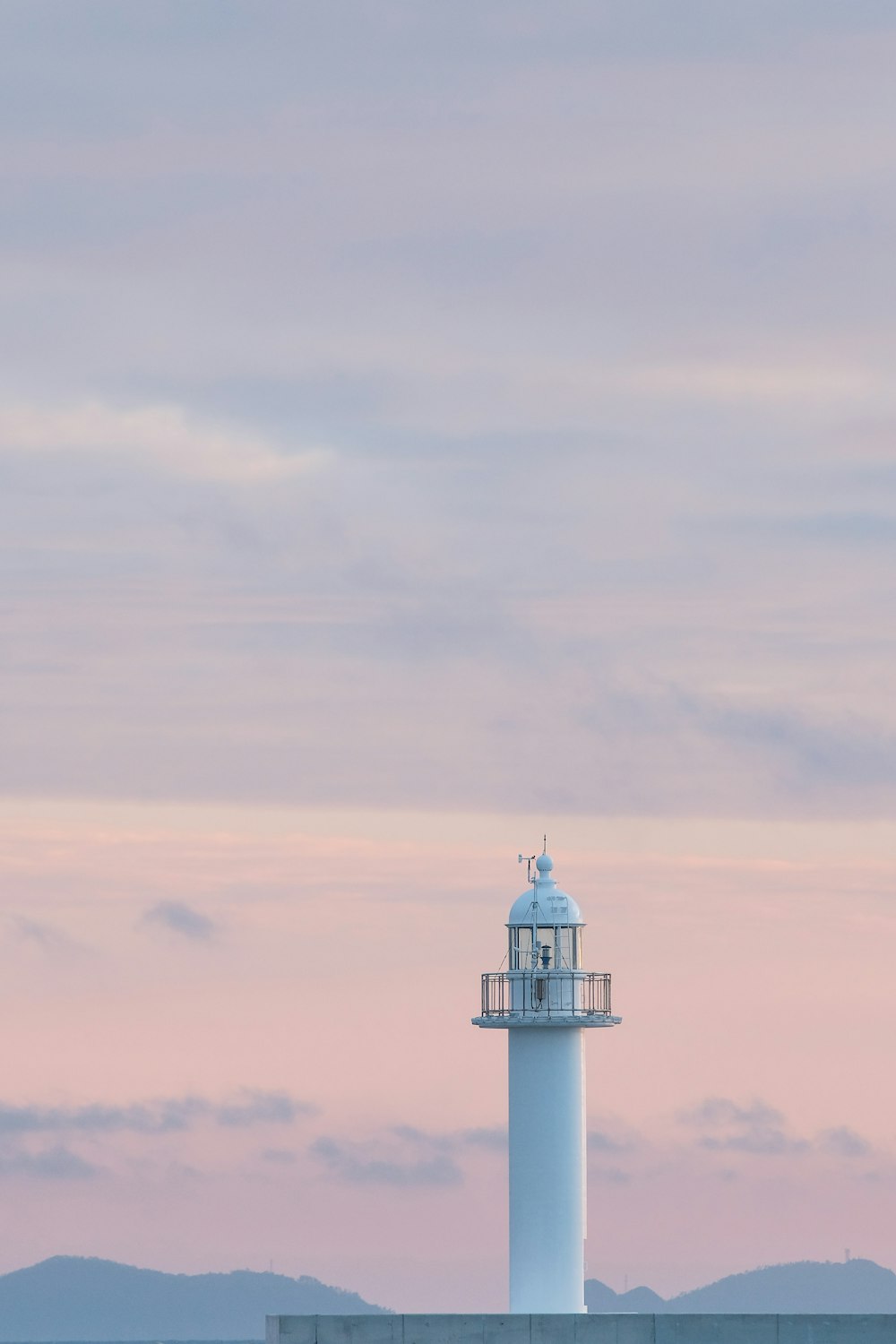 white and black lighthouse under white clouds during daytime