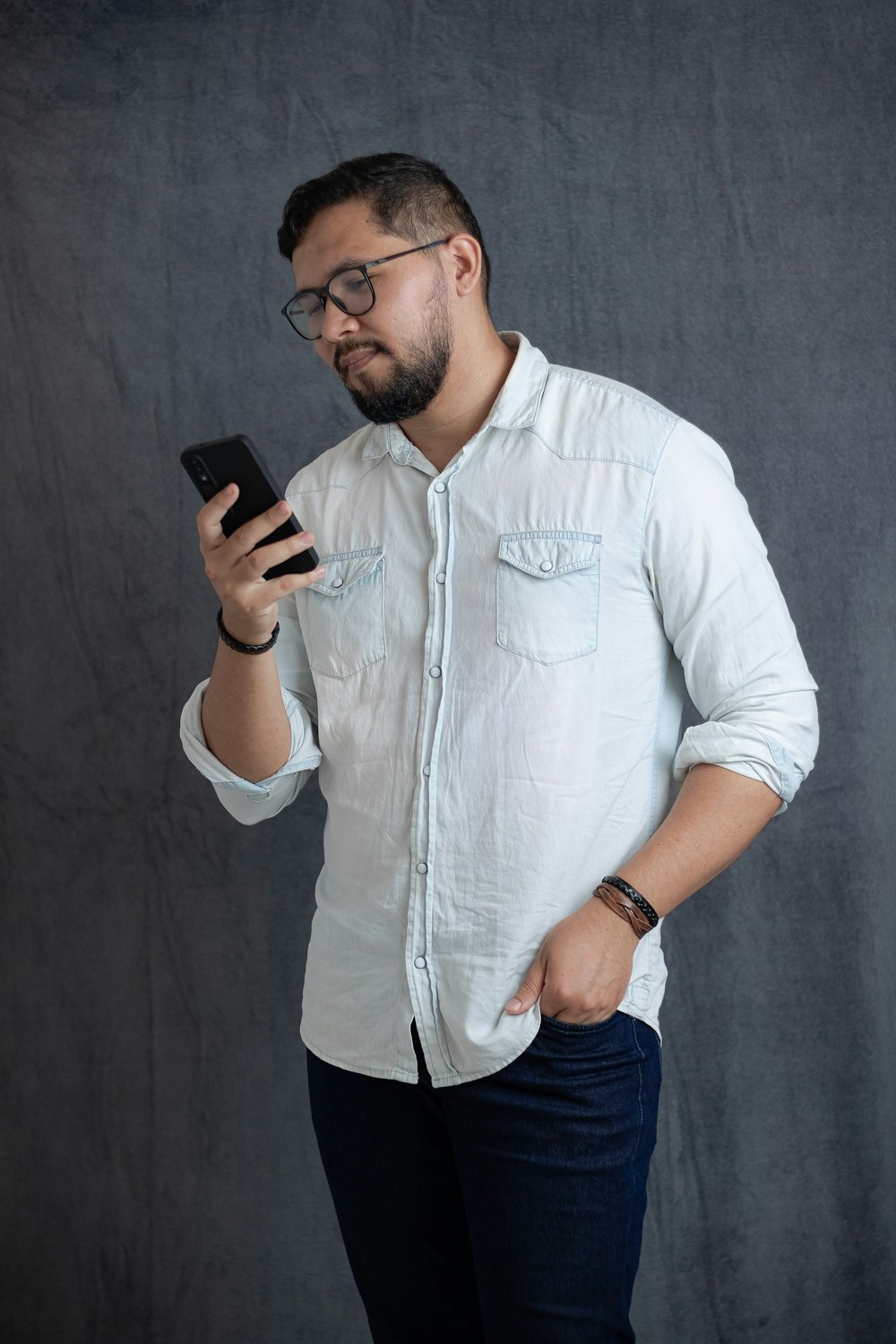 Foto Hombre de camisa blanca con botones sosteniendo un smartphone negro –  Imagen Brasil gratis en Unsplash