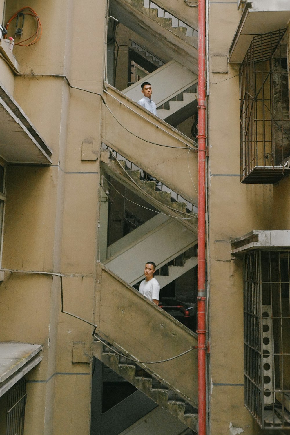 woman in white long sleeve shirt and black pants standing on gray concrete stairs