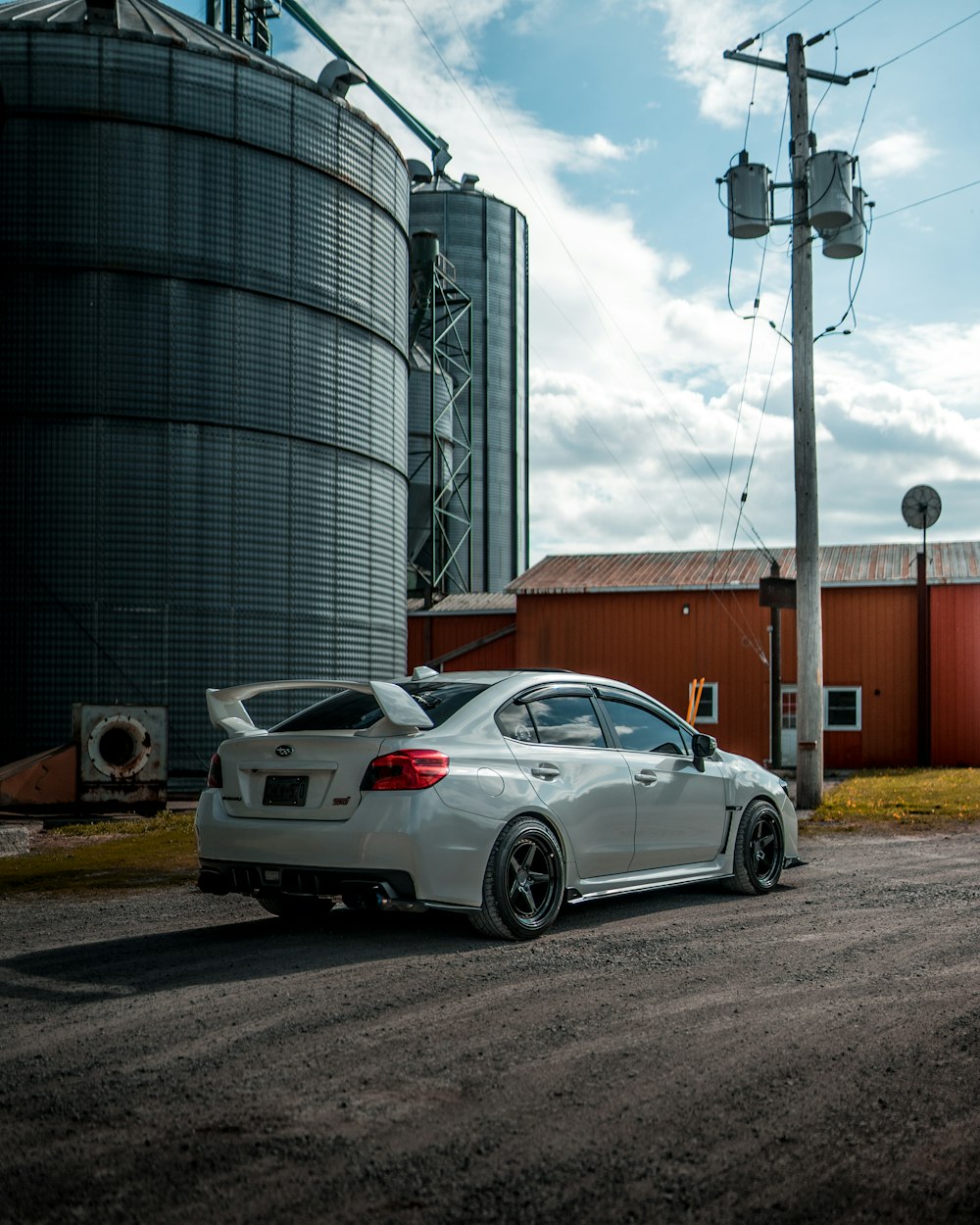 white sedan parked beside brown building