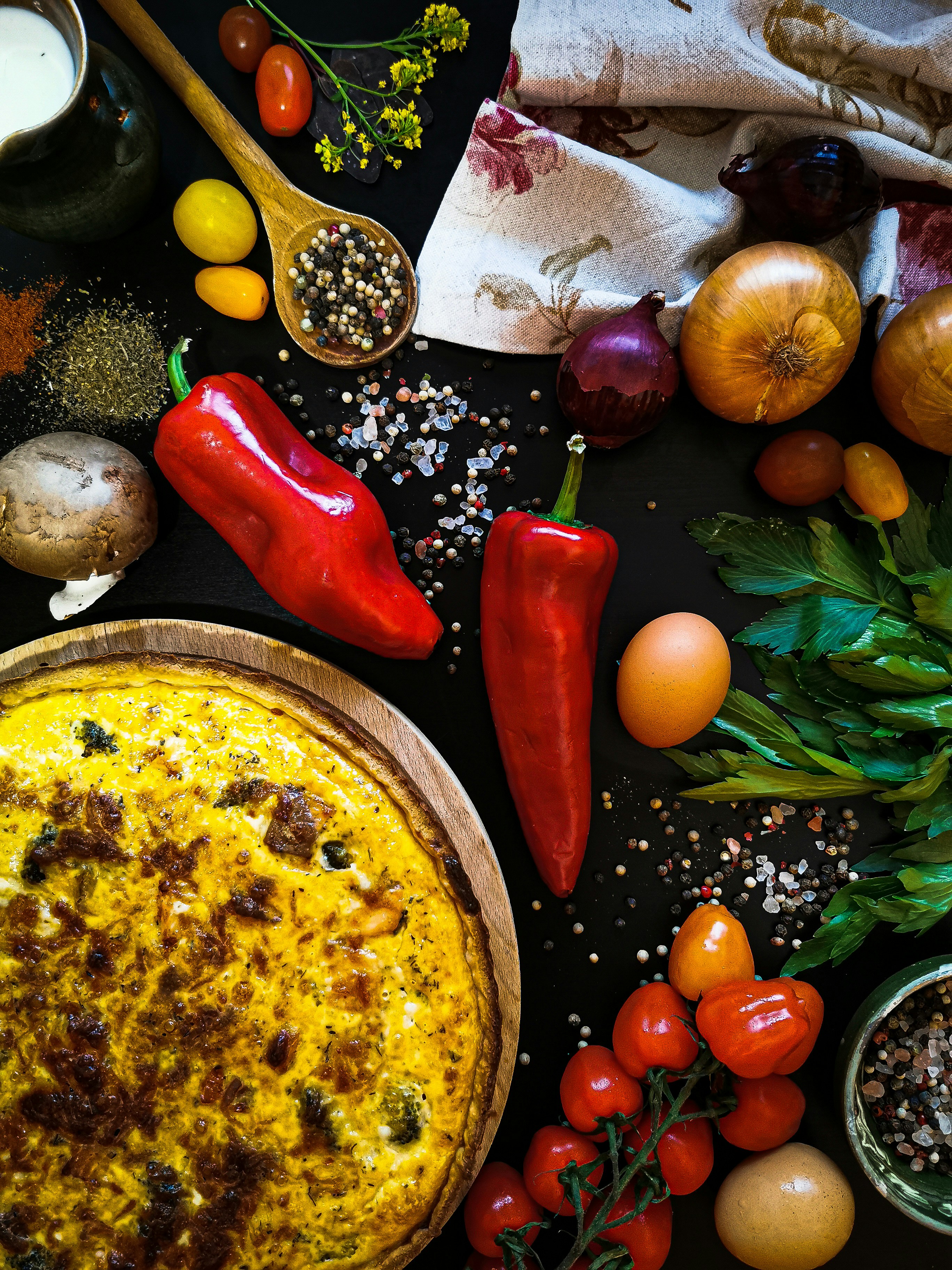 Red chili pepper and green leaves on a brown wooden plate
