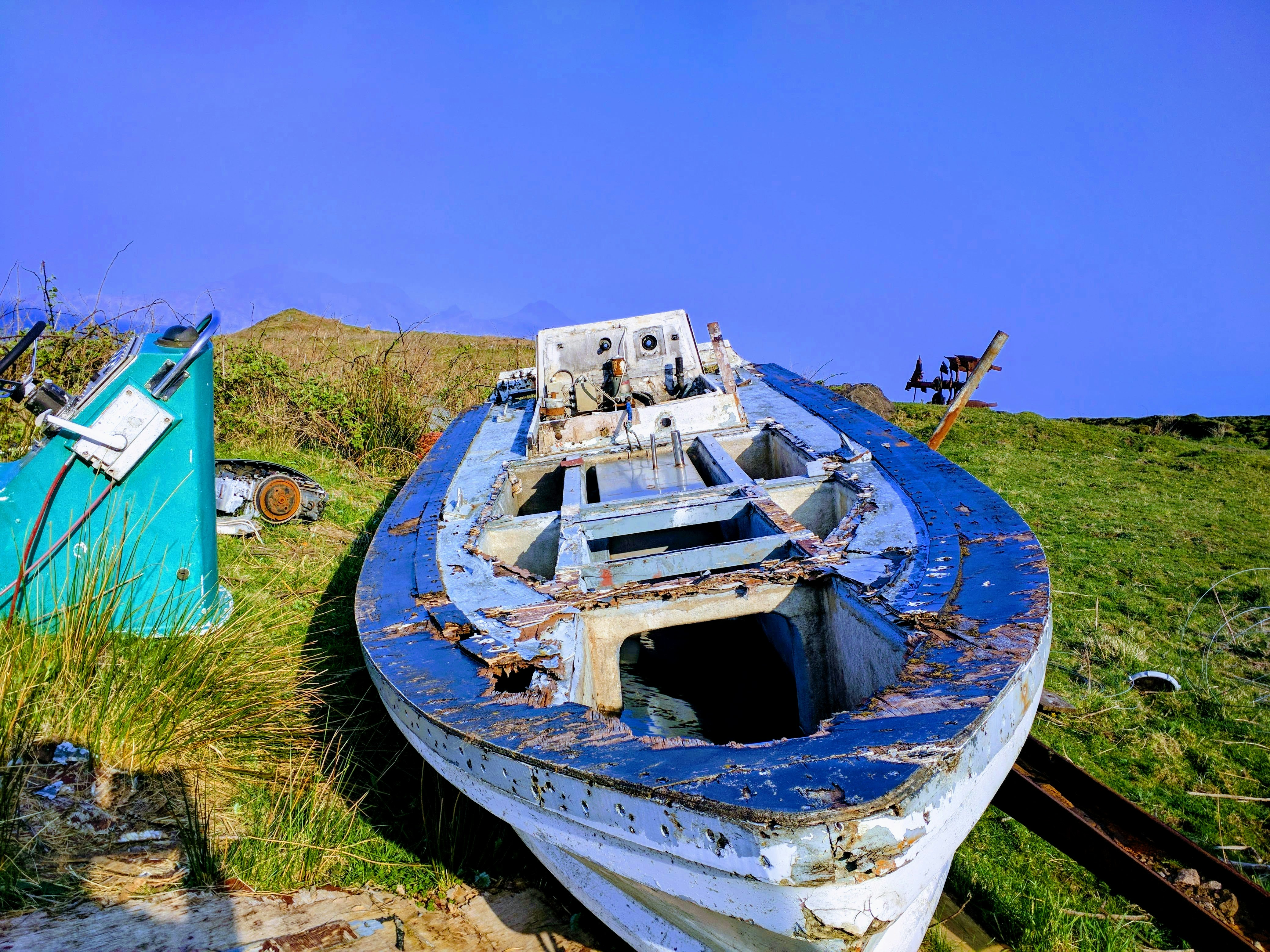 white and blue ship on green grass field during daytime