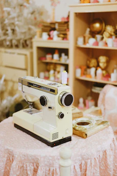 white and gold sewing machine on white table