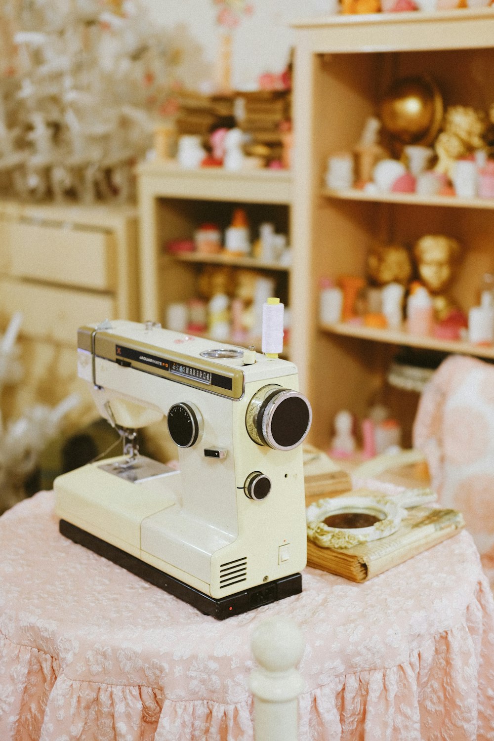 white and gold sewing machine on white table