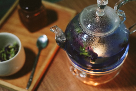 stainless steel teapot on brown wooden table