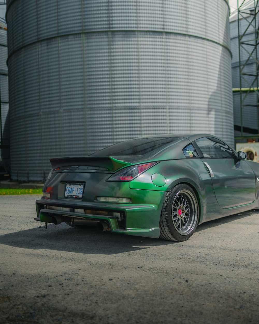 Porsche 911 verte garée près d’un bâtiment gris