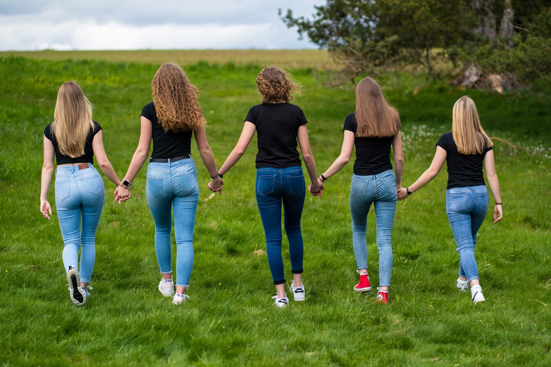 3 women standing on green grass field during daytime