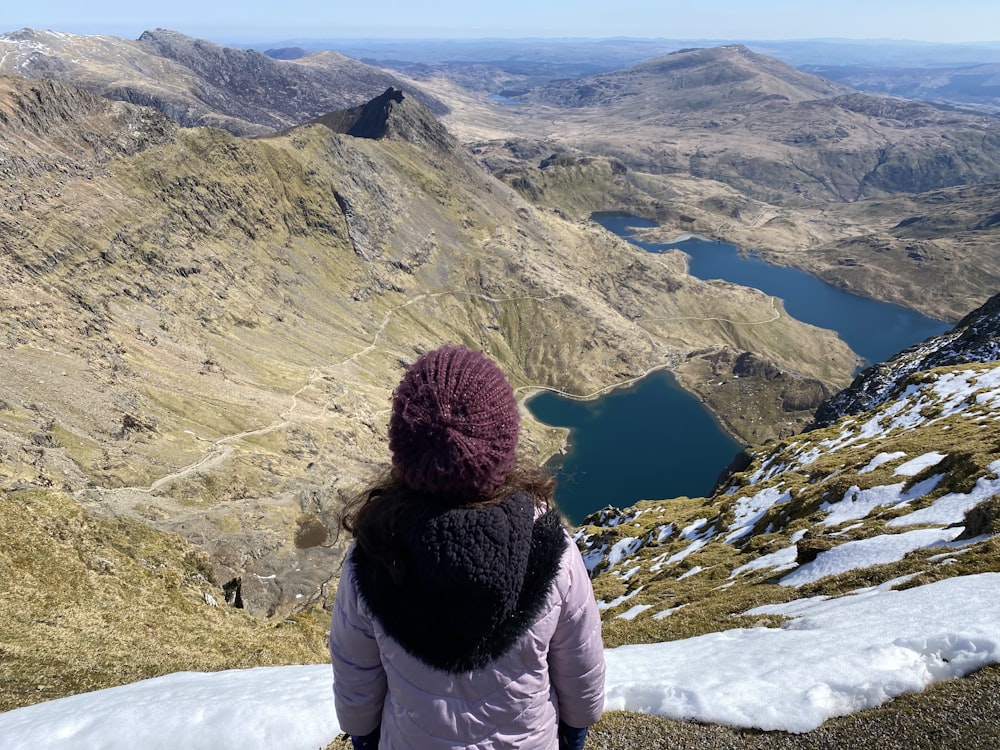 woman in white jacket standing on snow covered ground during daytime