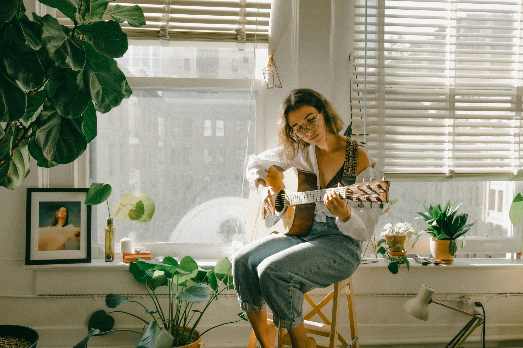 Girl playing guitar in the sunlight. Shot on Lumix S1. 