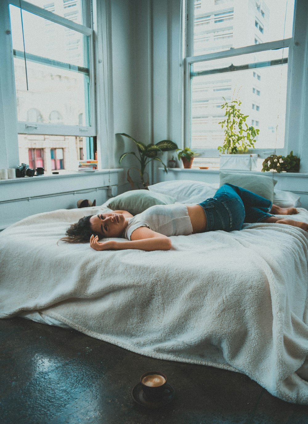 ベッドに横たわるブルーデニムのショートパンツの女性