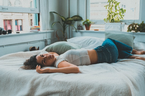 woman in blue denim shorts lying on bed