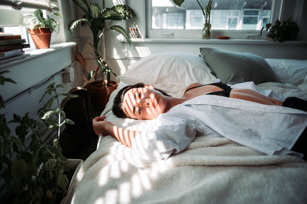 woman in white robe lying on bed