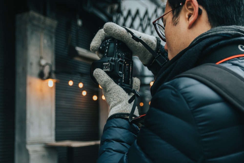 man in black jacket holding black video camera