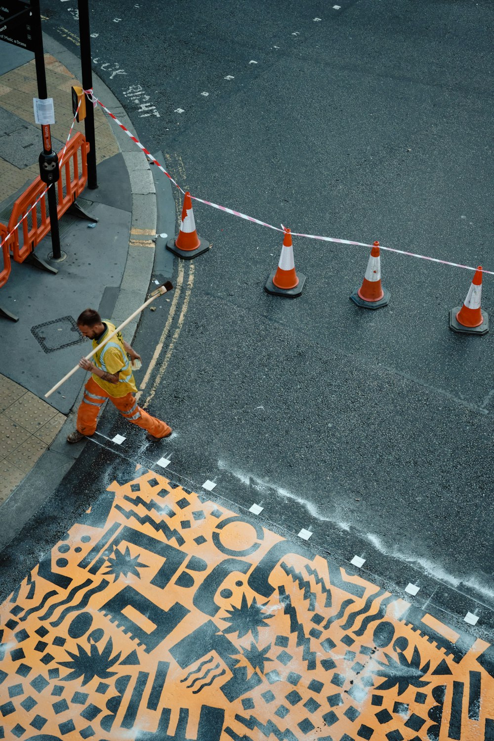 man in yellow shirt and blue denim jeans walking on pedestrian lane during daytime