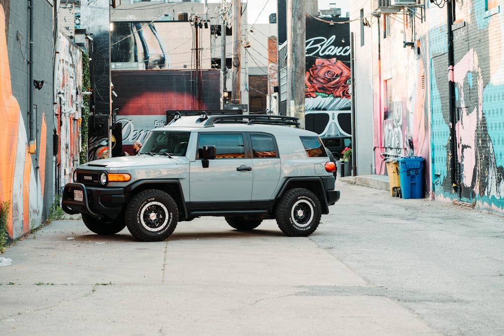 white and black suv parked beside white concrete building during daytime