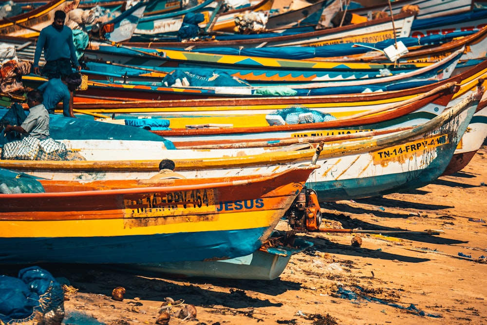 yellow and blue boats on brown sand during daytime