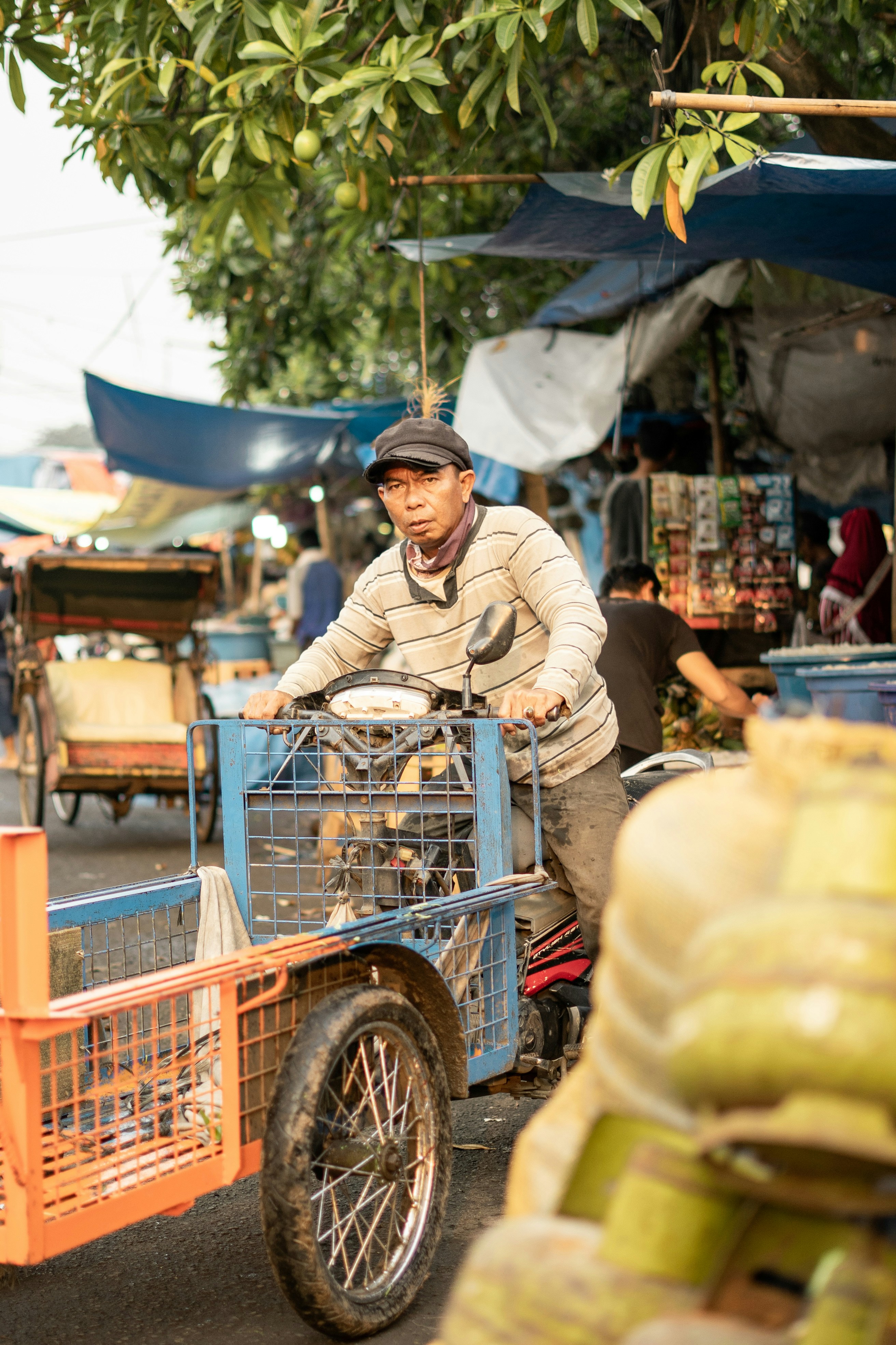 man in brown jacket and brown hat riding on red and black cart during daytime