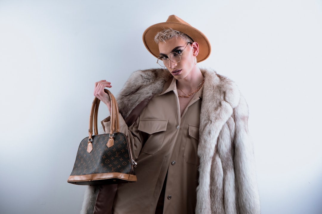 woman in brown coat wearing brown hat and brown leather shoulder bag