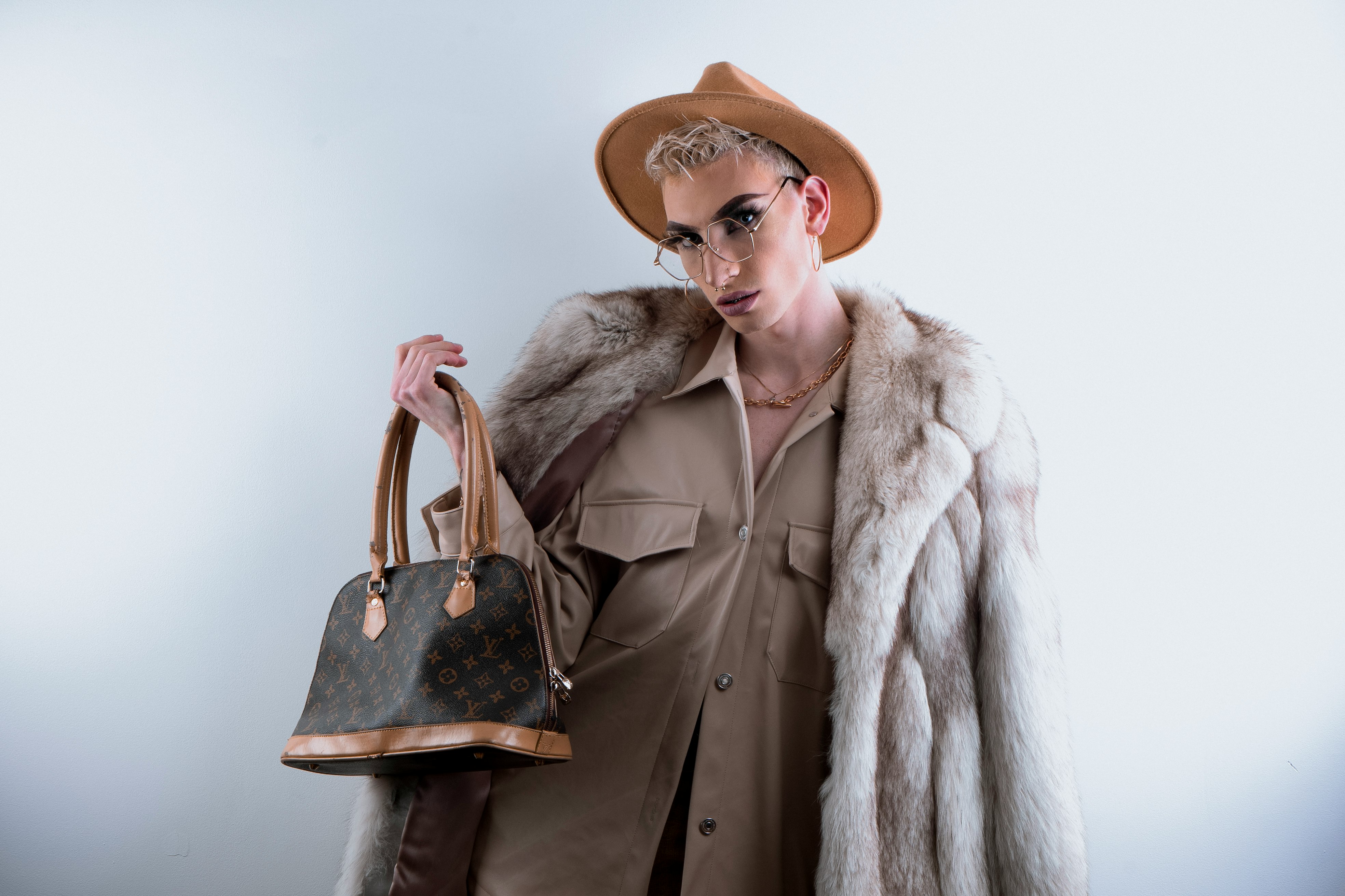 woman in brown coat wearing brown hat and brown leather shoulder bag
