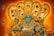 A traditional Indian artwork depicting a deity with blue skin adorned in intricate golden jewelry and ornaments, surrounded by multiple hooded cobras. The background features warm shades of orange and gold, adding to the mythical and spiritual ambiance.