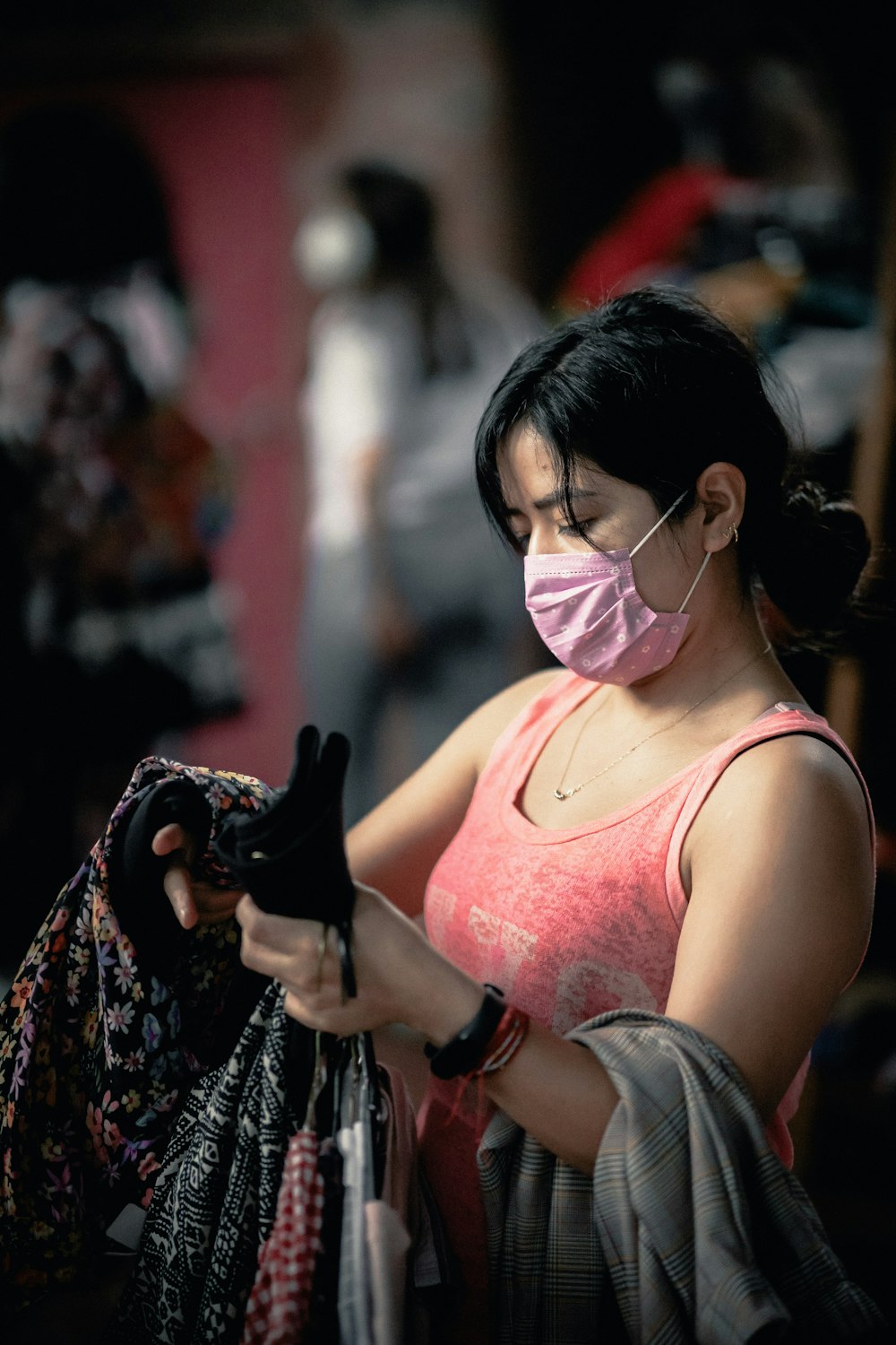 woman in pink tank top holding black dslr camera