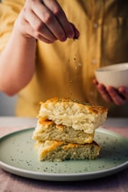 person holding white ceramic bowl with bread
