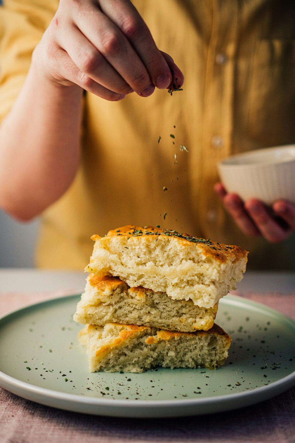 person holding white ceramic bowl with bread