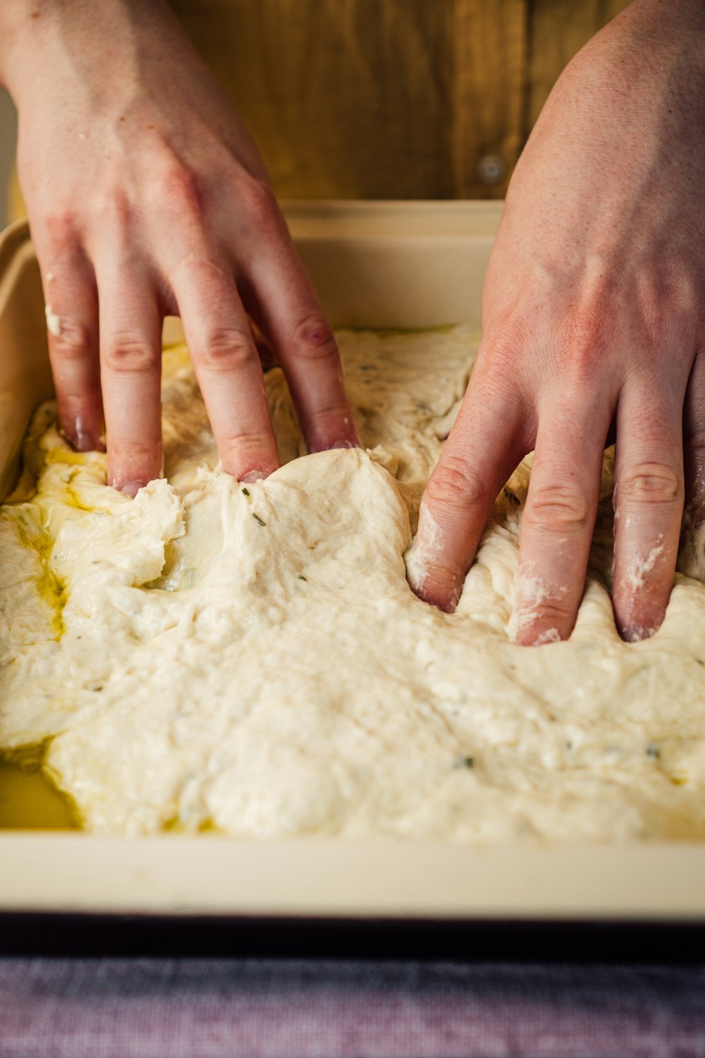 Persona che tiene l'impasto bianco sul tavolo bianco