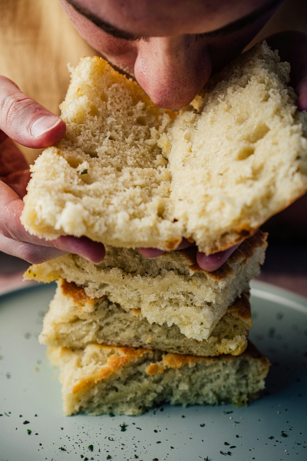 person holding bread with ham and cheese