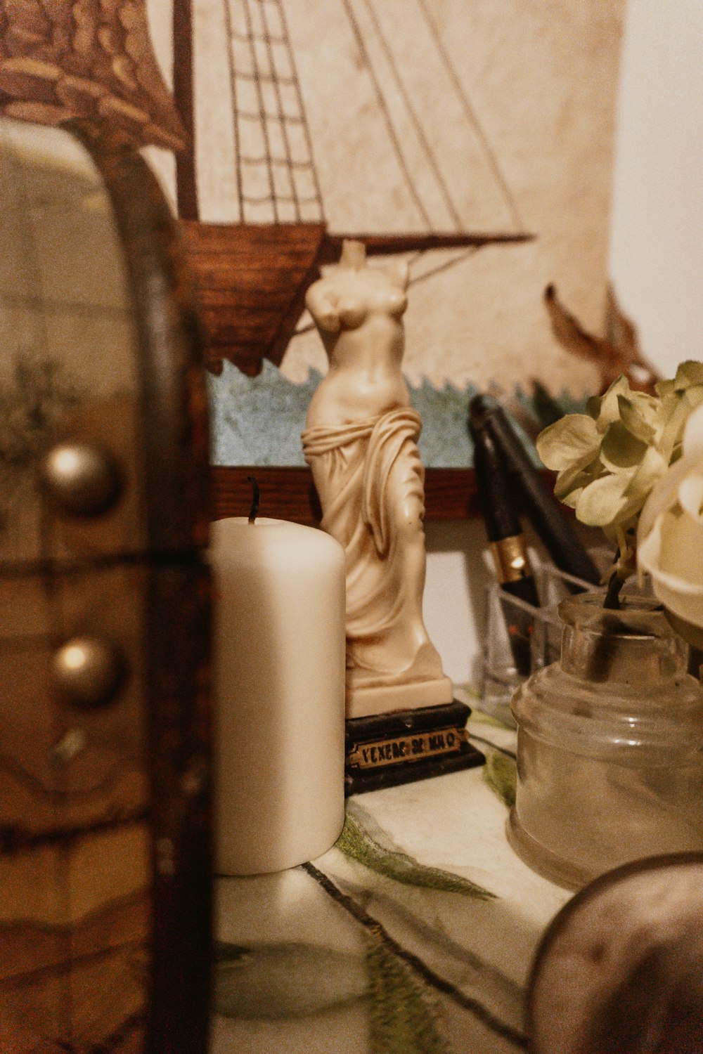 Figurine d’ange en céramique blanche à côté de la bougie pilier blanc
