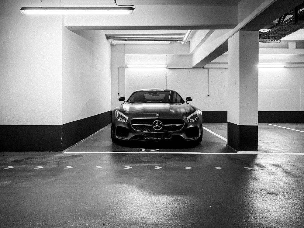 grayscale photo of car parked in tunnel